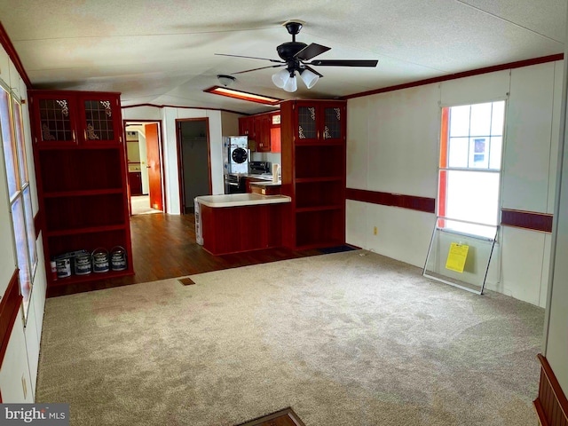 unfurnished living room featuring ceiling fan, dark carpet, crown molding, and lofted ceiling