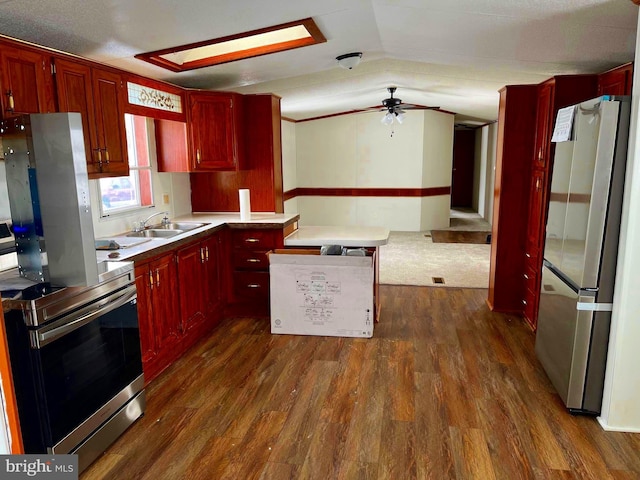 kitchen featuring ceiling fan, sink, dark wood-type flooring, stainless steel appliances, and lofted ceiling