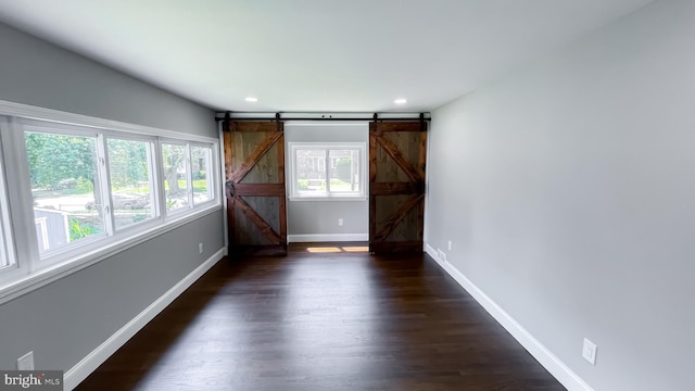 empty room featuring dark hardwood / wood-style floors and a barn door