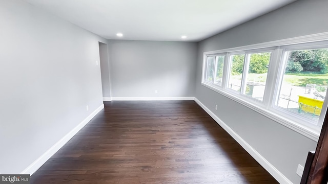 unfurnished room with dark hardwood / wood-style flooring