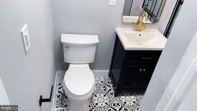 bathroom with toilet, tile patterned floors, and vanity