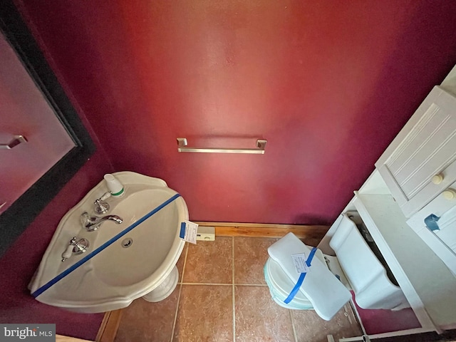 bathroom featuring sink, toilet, and tile patterned flooring