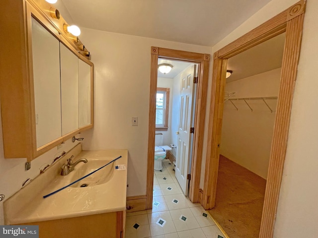 bathroom featuring toilet, tile patterned flooring, and vanity