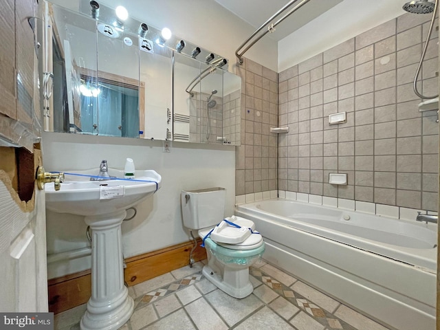 bathroom featuring tiled shower / bath combo, toilet, and tile patterned floors