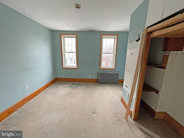 carpeted empty room with radiator