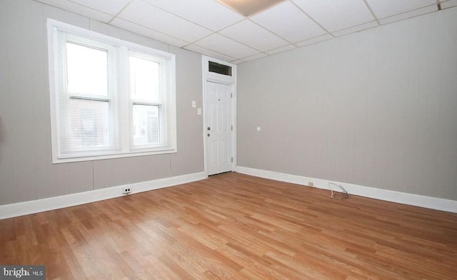 spare room with wood-type flooring and a drop ceiling