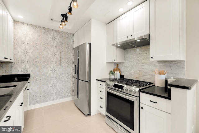 kitchen with light tile patterned floors, white cabinets, appliances with stainless steel finishes, and sink