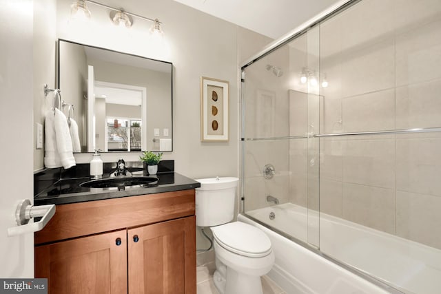 full bathroom featuring enclosed tub / shower combo, vanity, and toilet