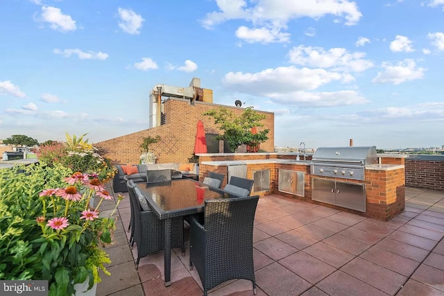 view of patio / terrace featuring exterior kitchen, sink, and a grill