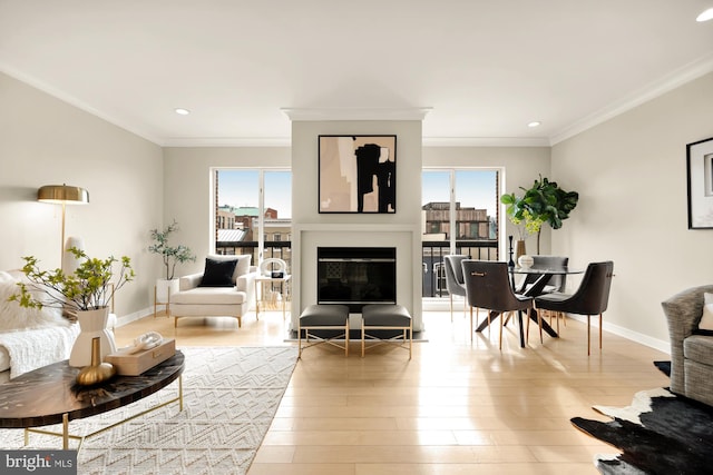 living room with a wealth of natural light, ornamental molding, and wood-type flooring