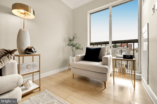 sitting room with light hardwood / wood-style flooring and crown molding