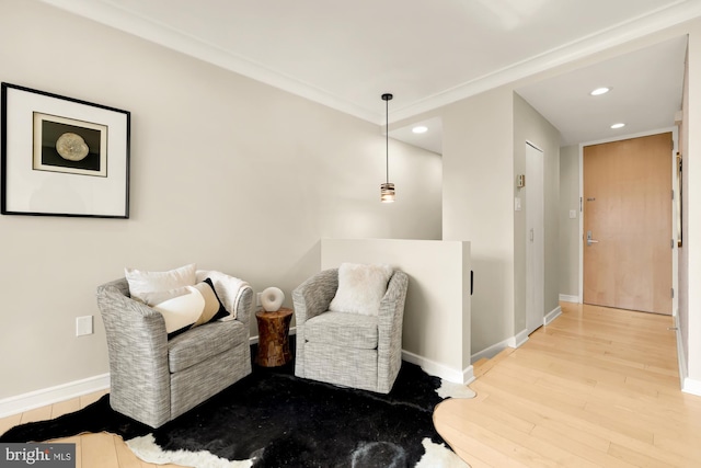 sitting room with light hardwood / wood-style floors and ornamental molding