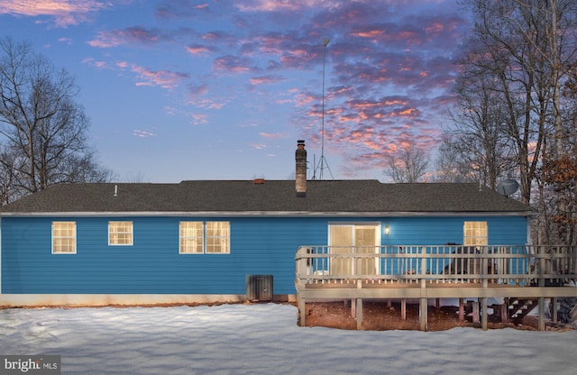 snow covered rear of property featuring a deck