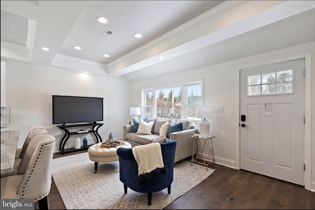 living room with a raised ceiling, ornamental molding, and dark hardwood / wood-style flooring