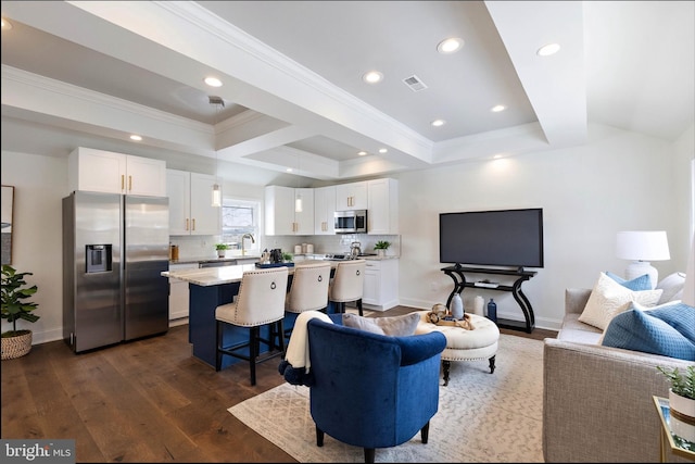 living room with sink, a tray ceiling, and dark hardwood / wood-style flooring