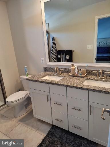 bathroom featuring toilet, tile patterned floors, and vanity