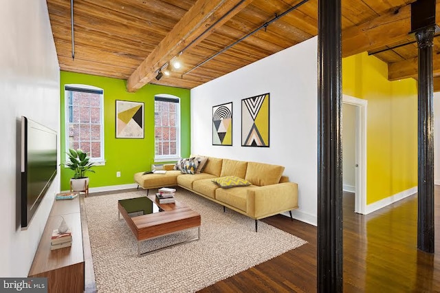 living room featuring dark hardwood / wood-style floors, track lighting, wooden ceiling, and beam ceiling