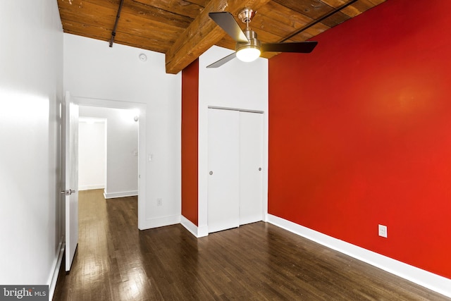 unfurnished bedroom with lofted ceiling with beams, dark hardwood / wood-style flooring, ceiling fan, and wood ceiling