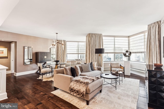 living room featuring an inviting chandelier, a baseboard heating unit, and hardwood / wood-style flooring