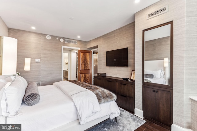 bedroom with dark wood-type flooring and ensuite bathroom