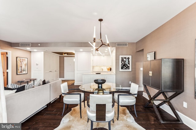 dining area with an inviting chandelier and dark hardwood / wood-style flooring