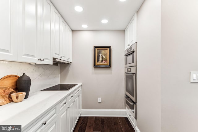 kitchen featuring dark wood-type flooring, white cabinetry, backsplash, light stone countertops, and black electric cooktop