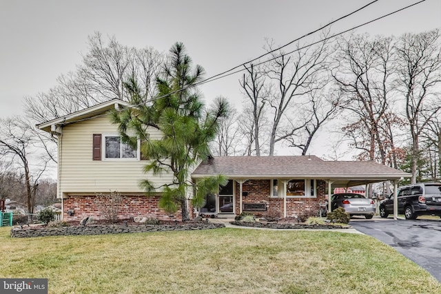 tri-level home with a front yard, aphalt driveway, a carport, and brick siding