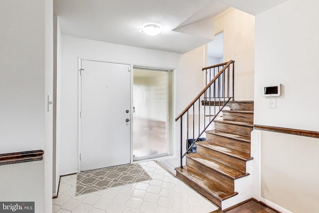 entrance foyer featuring stairway, baseboards, and tile patterned floors