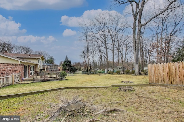 view of yard featuring fence and a wooden deck