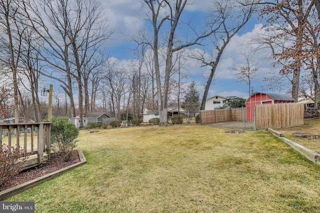 view of yard with a shed, fence, and an outdoor structure