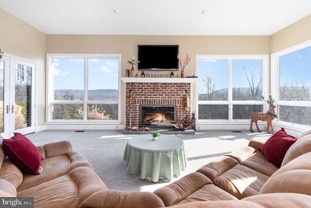 carpeted living room with a fireplace and french doors