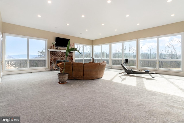 living room featuring a brick fireplace and light colored carpet