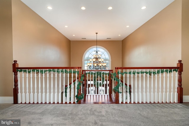 hall with carpet and an inviting chandelier