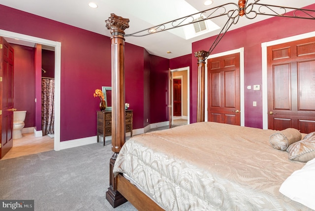 bedroom with connected bathroom and carpet flooring