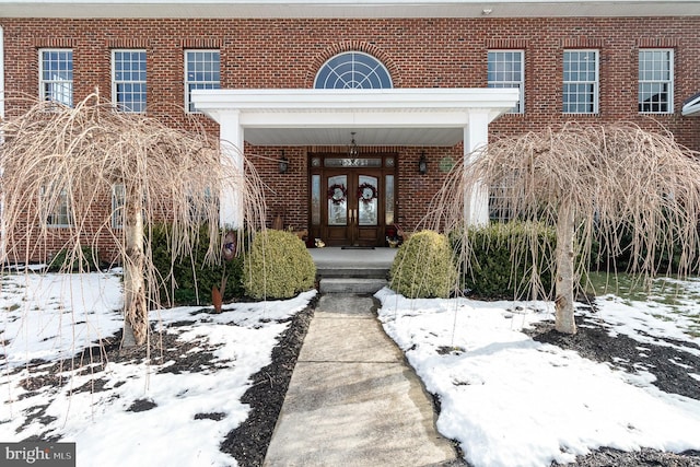 snow covered property entrance with french doors