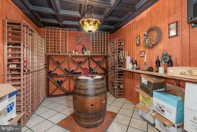 wine room with coffered ceiling, light tile patterned floors, and wood walls