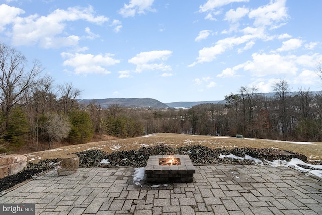 view of patio / terrace with a mountain view and an outdoor fire pit