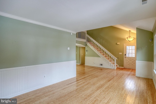 spare room featuring lofted ceiling and light hardwood / wood-style floors