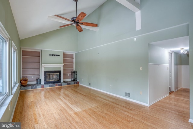 unfurnished living room with a healthy amount of sunlight, light hardwood / wood-style floors, and high vaulted ceiling