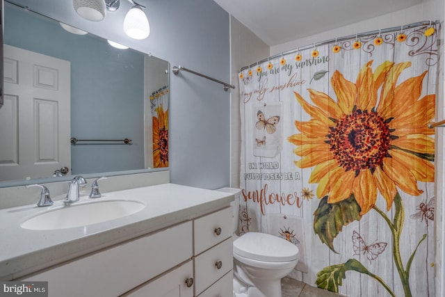 bathroom with tile patterned floors, vanity, toilet, and curtained shower