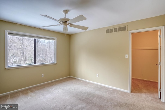 carpeted spare room featuring ceiling fan