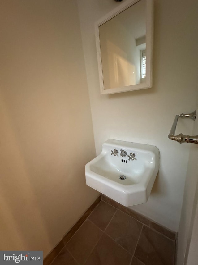 bathroom with tile patterned flooring, a sink, and baseboards