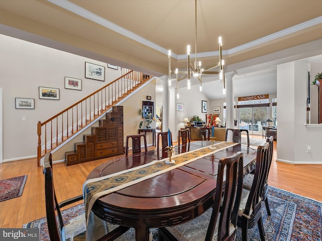 dining space with an inviting chandelier, ornamental molding, light hardwood / wood-style floors, and decorative columns