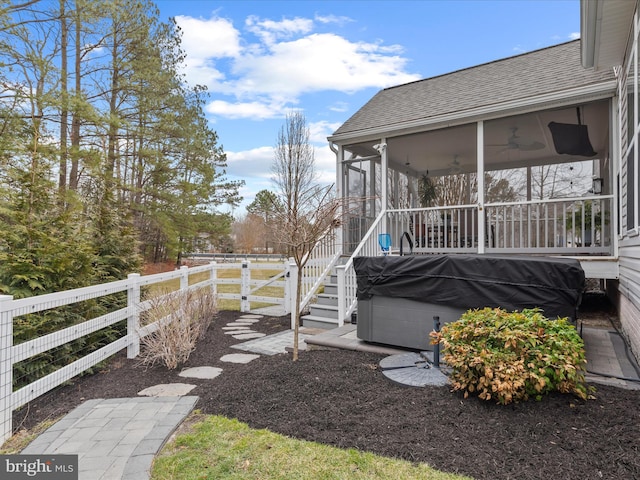 view of yard featuring a sunroom, a hot tub, and ceiling fan