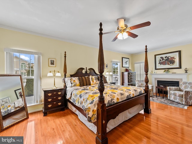 bedroom featuring multiple windows, crown molding, and light hardwood / wood-style floors