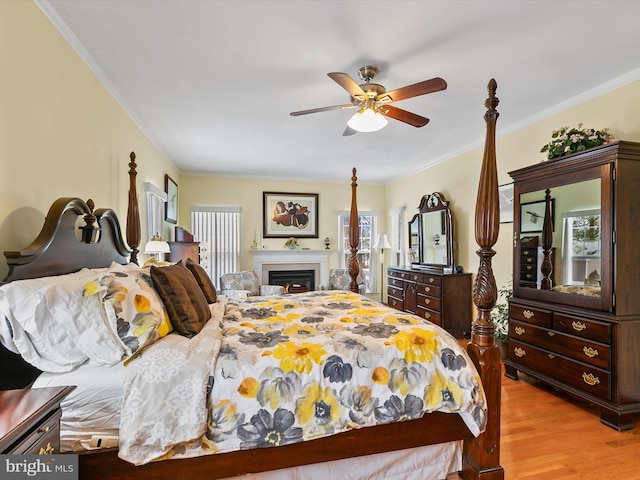 bedroom with ornamental molding, ceiling fan, and light hardwood / wood-style flooring