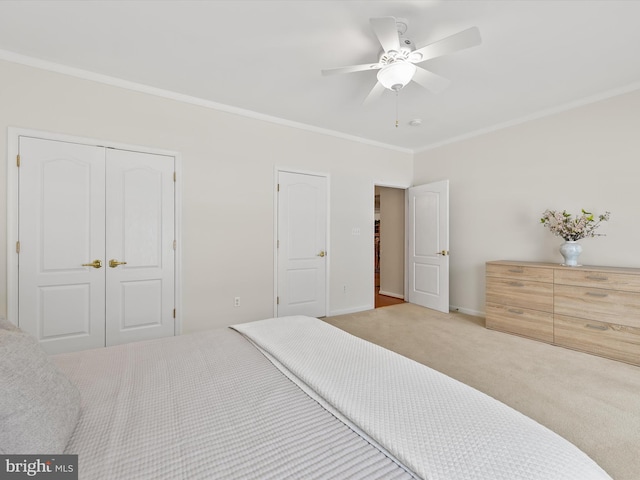 bedroom featuring ceiling fan, ornamental molding, light carpet, and a closet