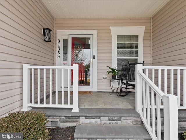 view of exterior entry featuring covered porch