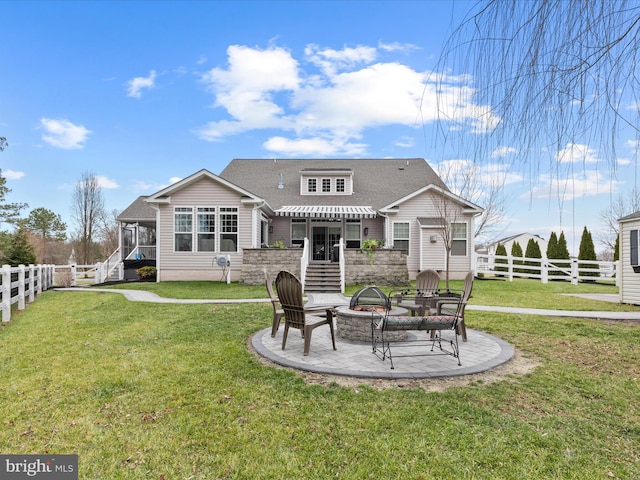 rear view of house featuring a patio, a fire pit, and a lawn