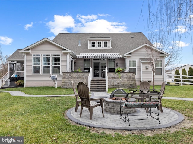 rear view of property with a yard, a patio area, and an outdoor fire pit